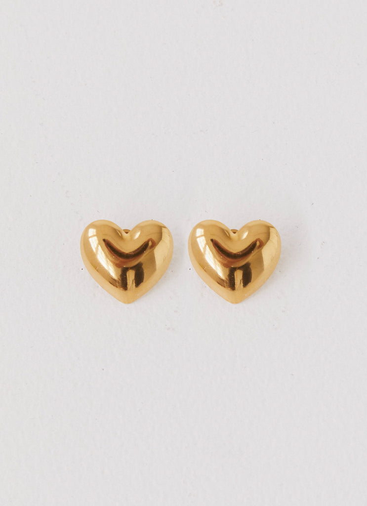 Womens Alexa Heart Earrings in the colour Gold in front of a light grey background