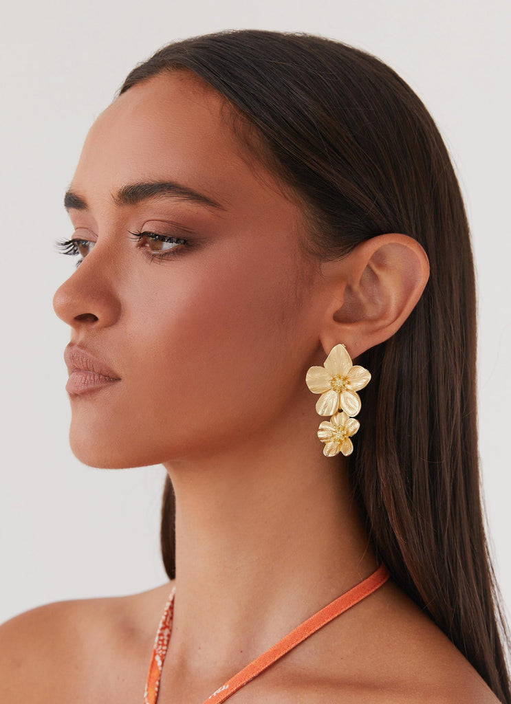 Womens Lola Love Flower Earrings in the colour Gold in front of a light grey background