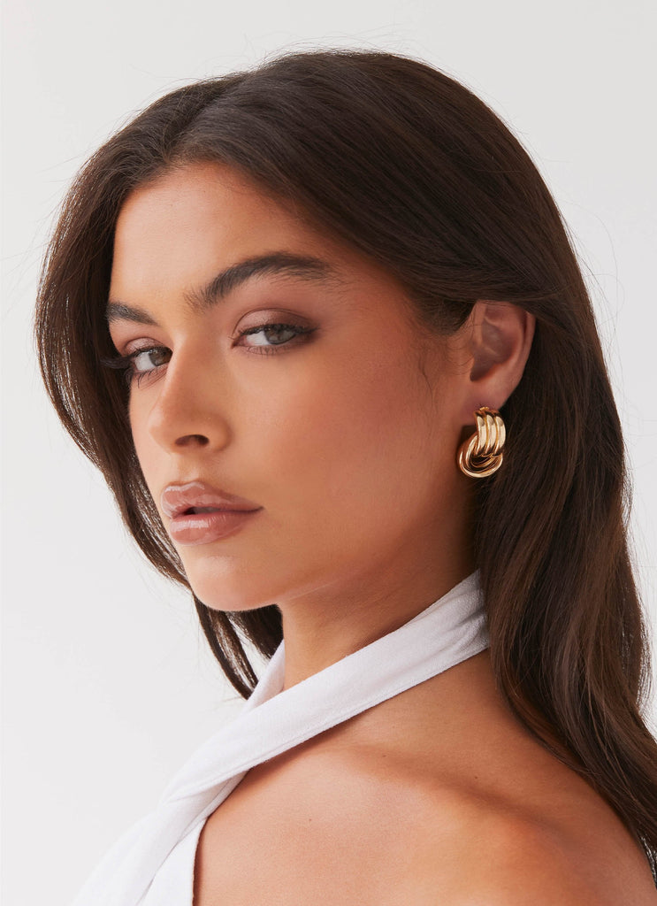 Womens Bold Step Cuff Earrings in the colour Gold in front of a light grey background