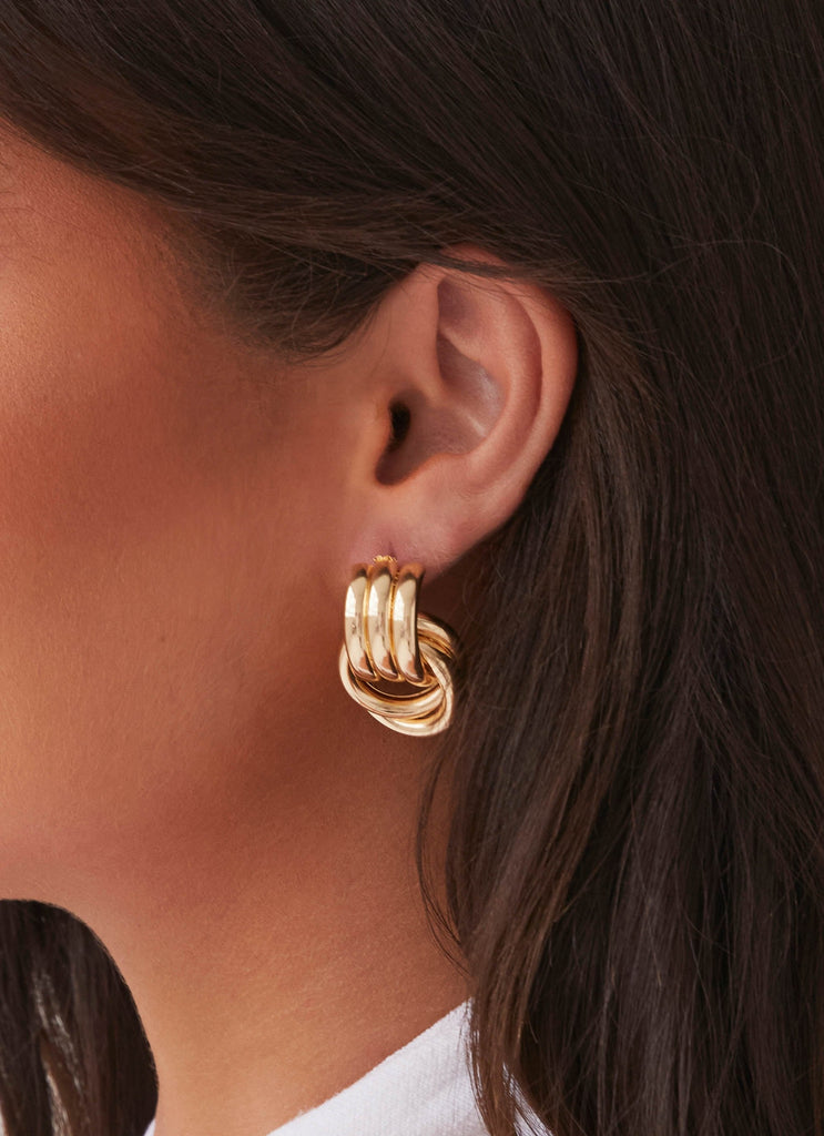 Womens Bold Step Cuff Earrings in the colour Gold in front of a light grey background