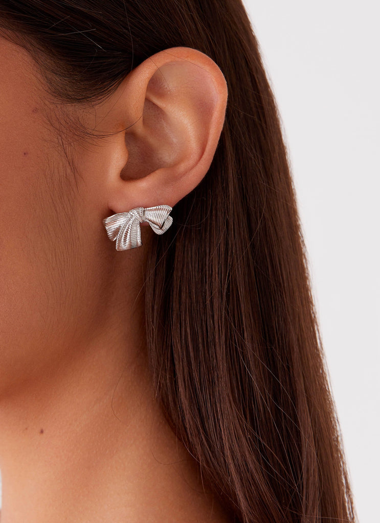 Womens Kiyah Bow Earrings in the colour Silver in front of a light grey background