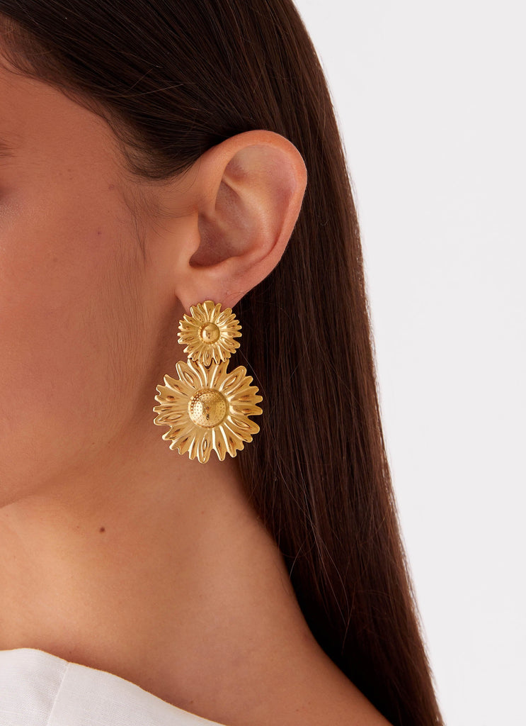 Womens Daisy Love Earrings in the colour Gold in front of a light grey background